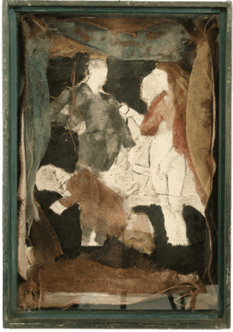 Assemblaggio in teca verde con fondo scuro, in cui sagome di figure umane bianche sono parzialmente coperte da garze e stracci colorati verde, rosso e marrone, che creano una scena quasi sacra ma lacerata.